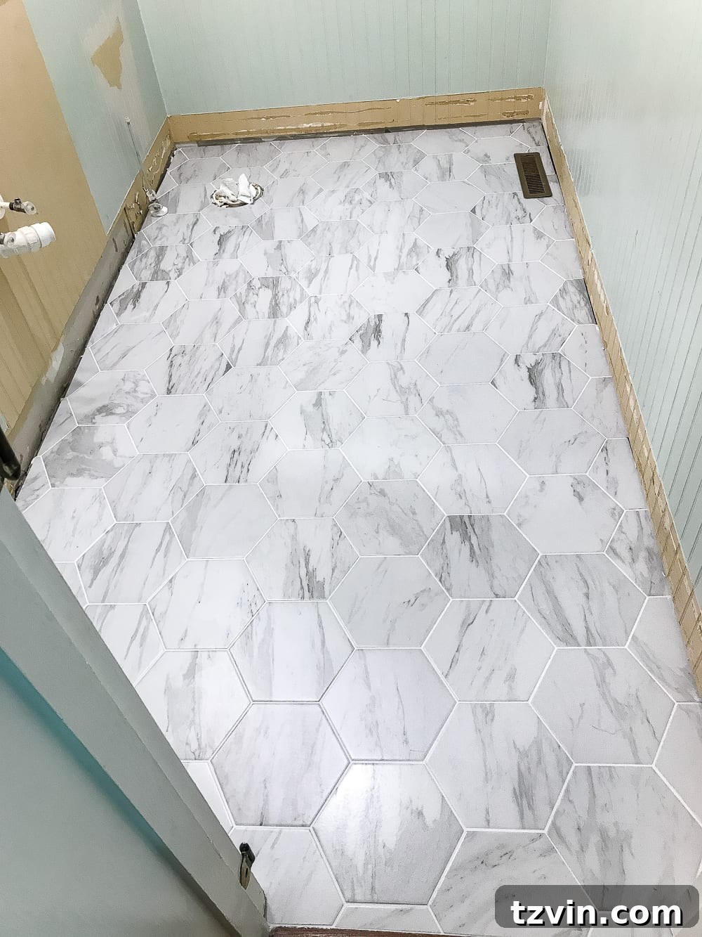 Powder Room Radiance: Faux Marble Tile Floor Upgrade 7 Newly installed faux marble hexagon tile in the powder room, showcasing its elegant and modern classic design. The tile mimics real Carrara marble beautifully.