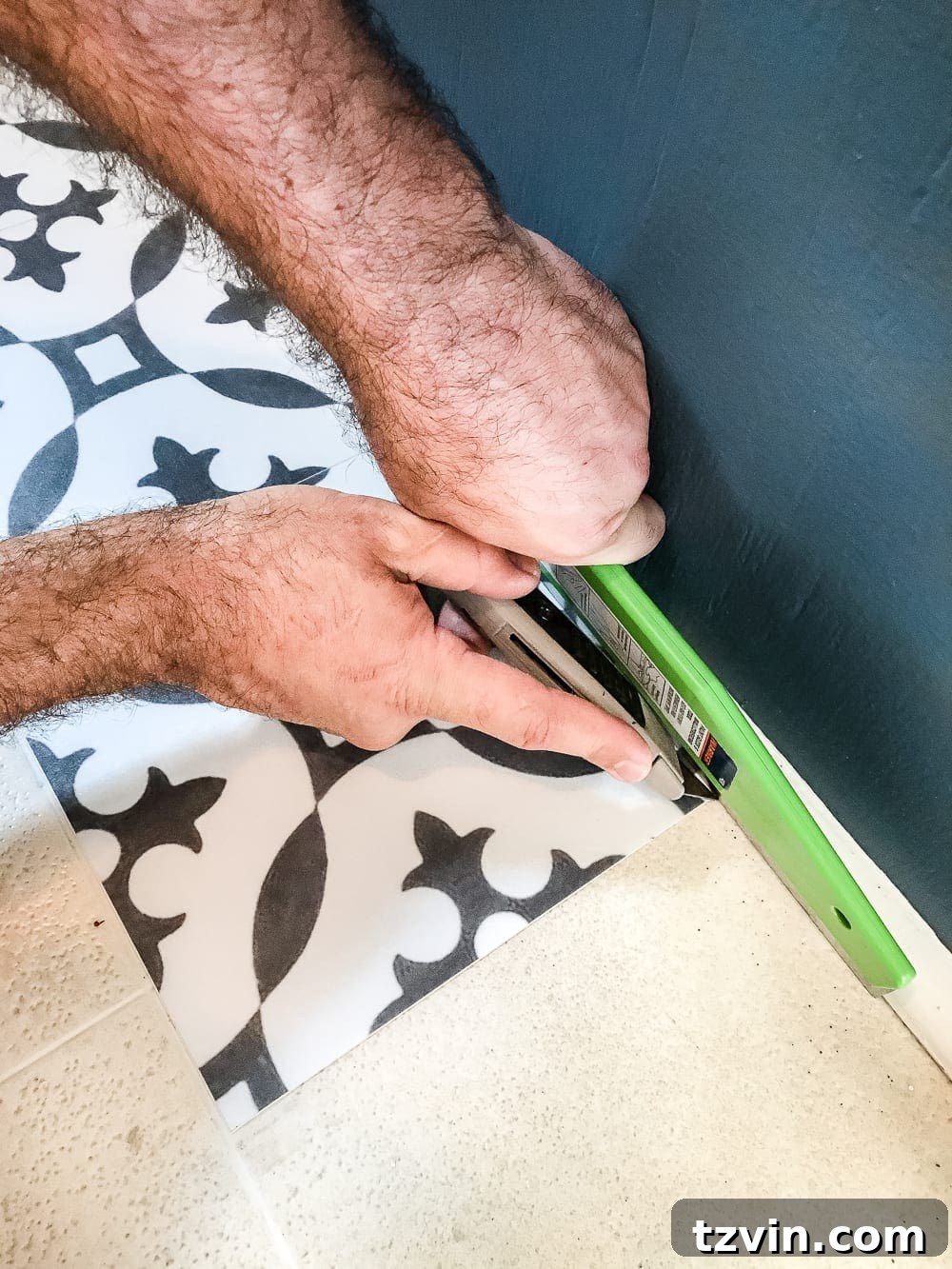 Smoothing down peel and stick vinyl tiles during installation.