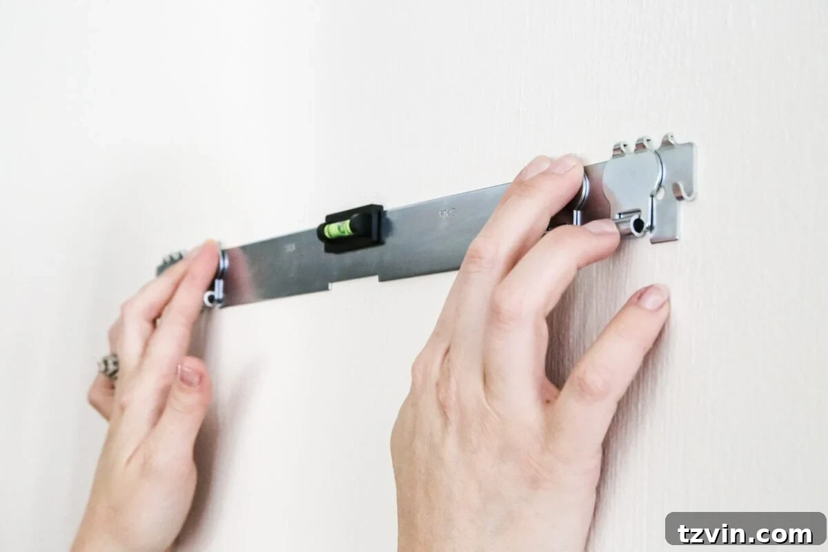 How to Hang Heavy Wall Decor Without Studs - Using the built-in level of High & Mighty hangers for precise installation.