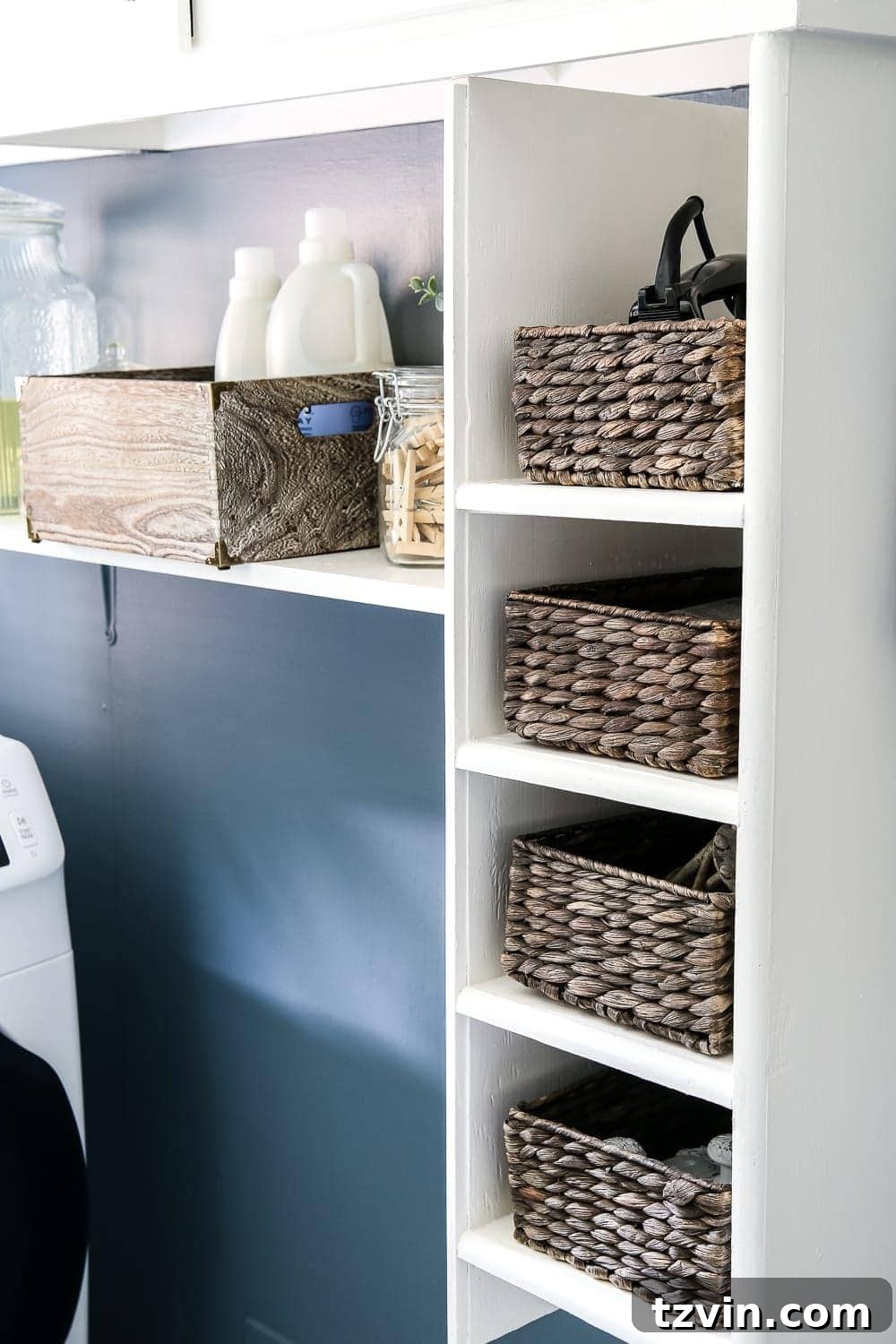 Bold Contrast Laundry Room Transformation 16 Close-up of organized storage baskets in laundry room, neatly tucked into cubbies.