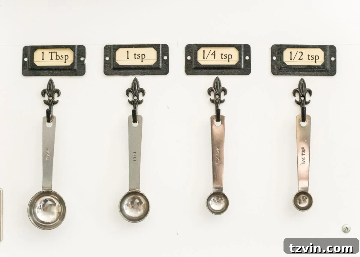 Pantry Cabinet Organization and Free Printable Label Set | blesserhouse.com - A cabinet gets a drastic organization makeover using inexpensive IKEA jars / baskets, hanging storage, and a free pantry label printable set. #organization 