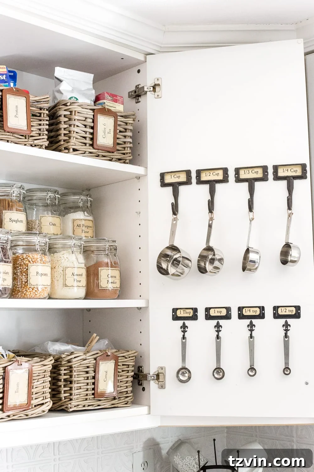 Pantry Cabinet Organization and Free Printable Label Set | blesserhouse.com - A cabinet gets a drastic organization makeover using inexpensive IKEA jars / baskets, hanging storage, and a free pantry label printable set. #organization 