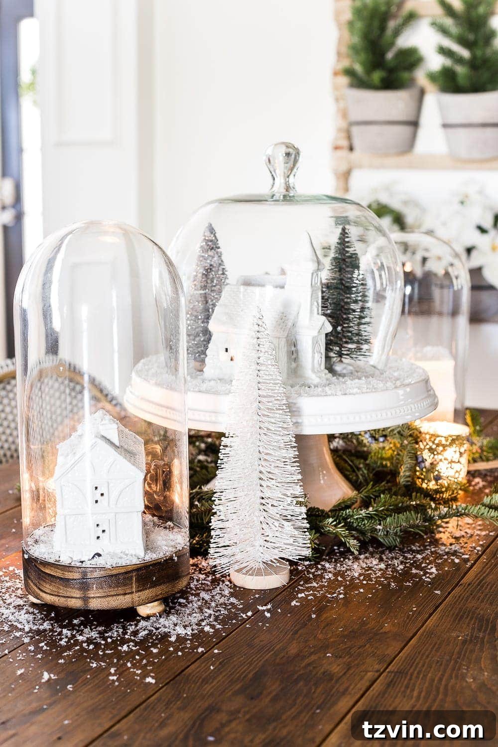 A close-up showing the detail of a white-painted Christmas village house within a dome clock, surrounded by fake snow and tiny trees.