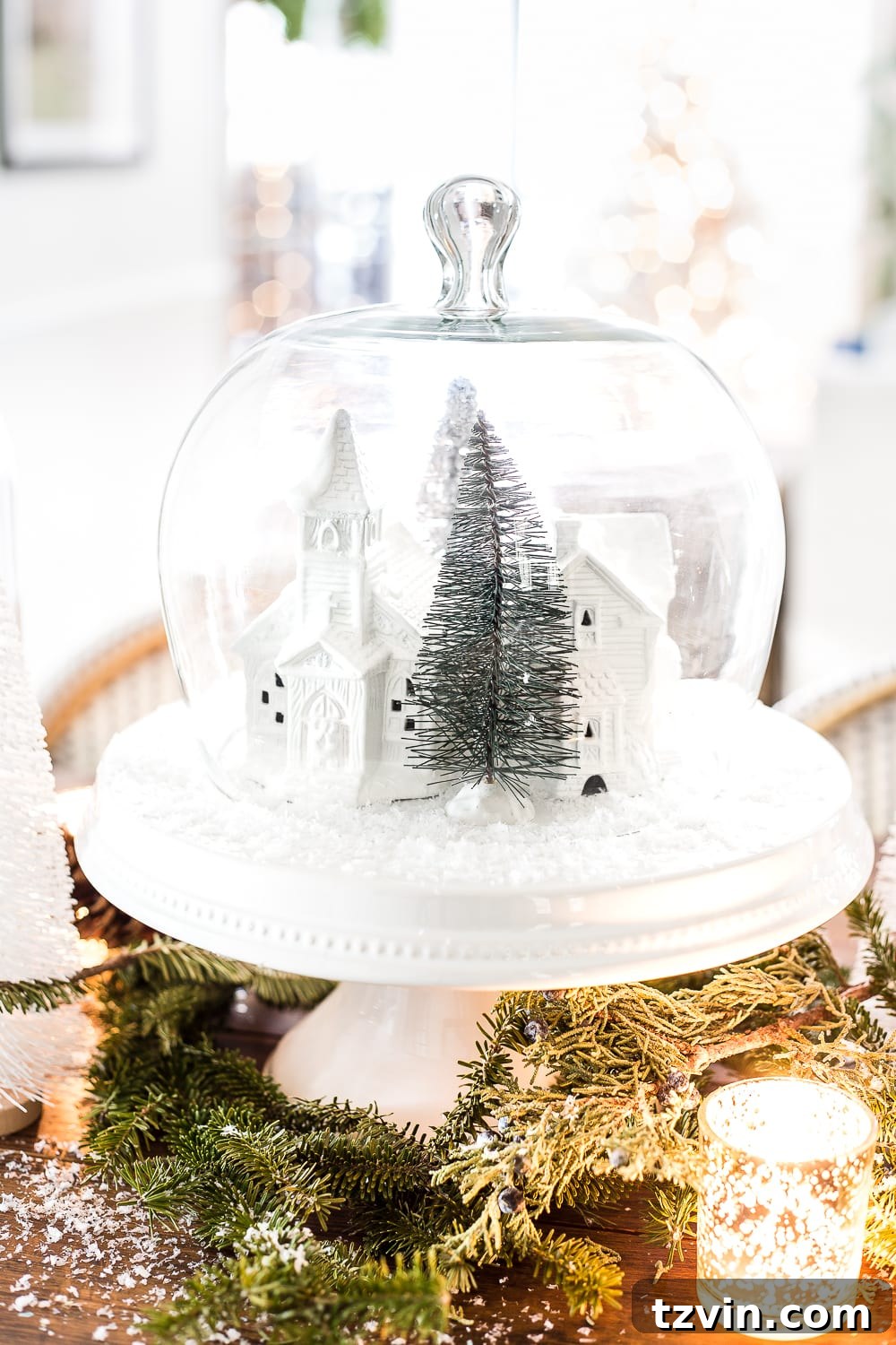 A detailed shot of the miniature scene inside a dome clock, showcasing the upcycled Christmas village and natural clippings.