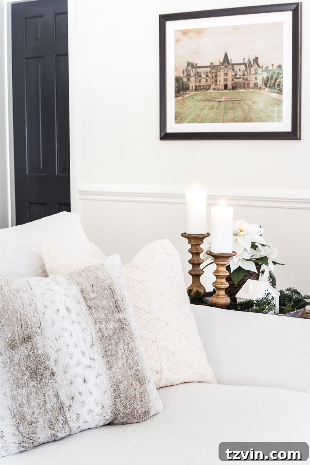 A wide shot of the neutral Christmas living room, showing the tree, fireplace, and comfortable seating with natural decor.