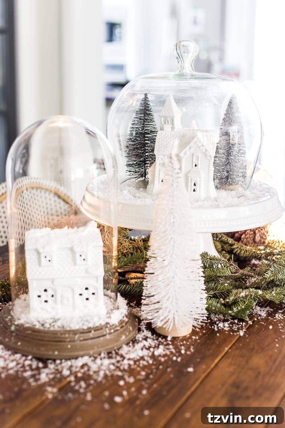 Christmas village snow globe centerpiece with white houses, creating a whimsical and natural holiday display.