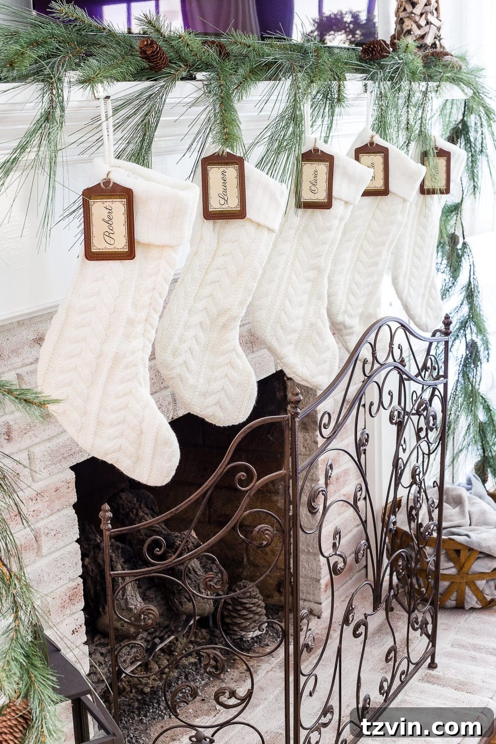 Elegant mercury glass candle holders and simple green wreaths enhancing a neutral Christmas console table decor.