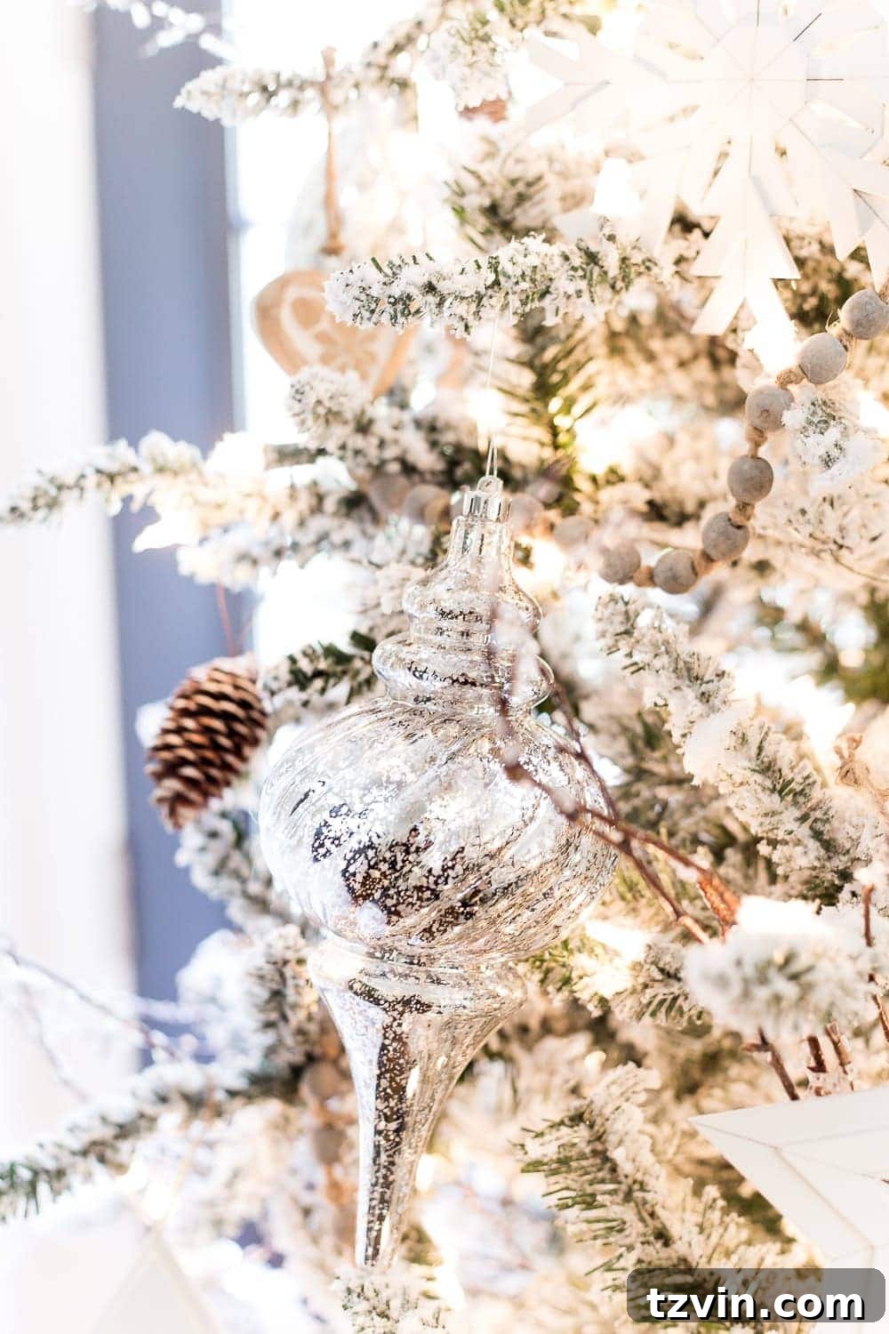 Charming Christmas breakfast nook with a decorative white village house, pinecones, and natural rustic touches.