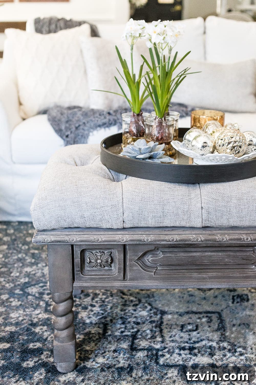 Elegant repurposed coffee table now a tufted ottoman in a cozy room