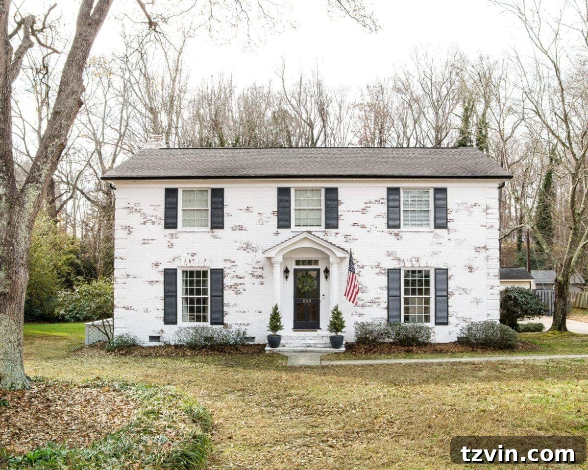 Romabio Bianco White limewash brick with Behr Cracked Pepper shutters and gutters and Behr Ultra Pure White trim