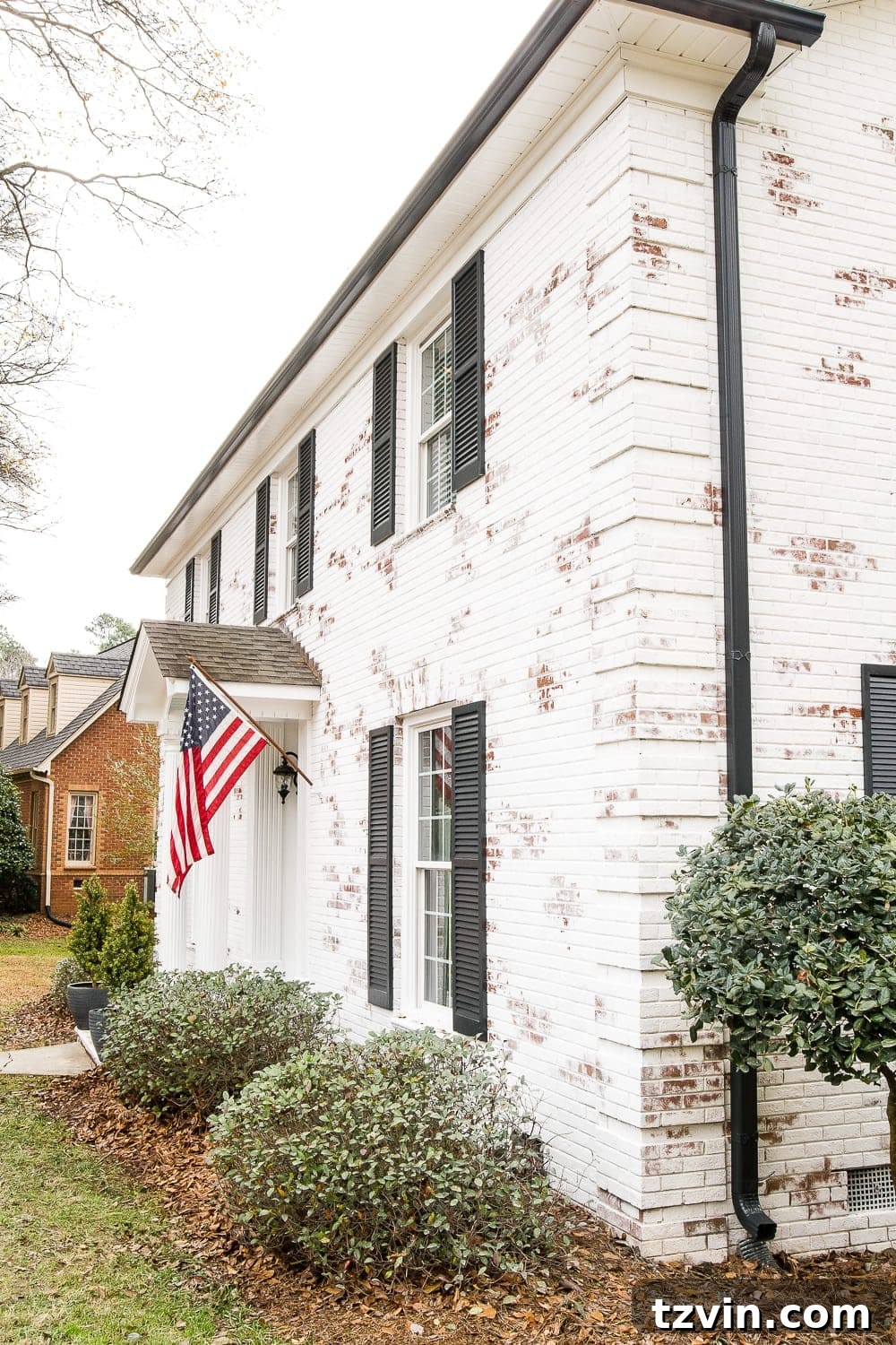 Romabio Bianco White brick with Behr Cracked Peppercorn Shutters and Gutters and Behr Ultra Pure White trim