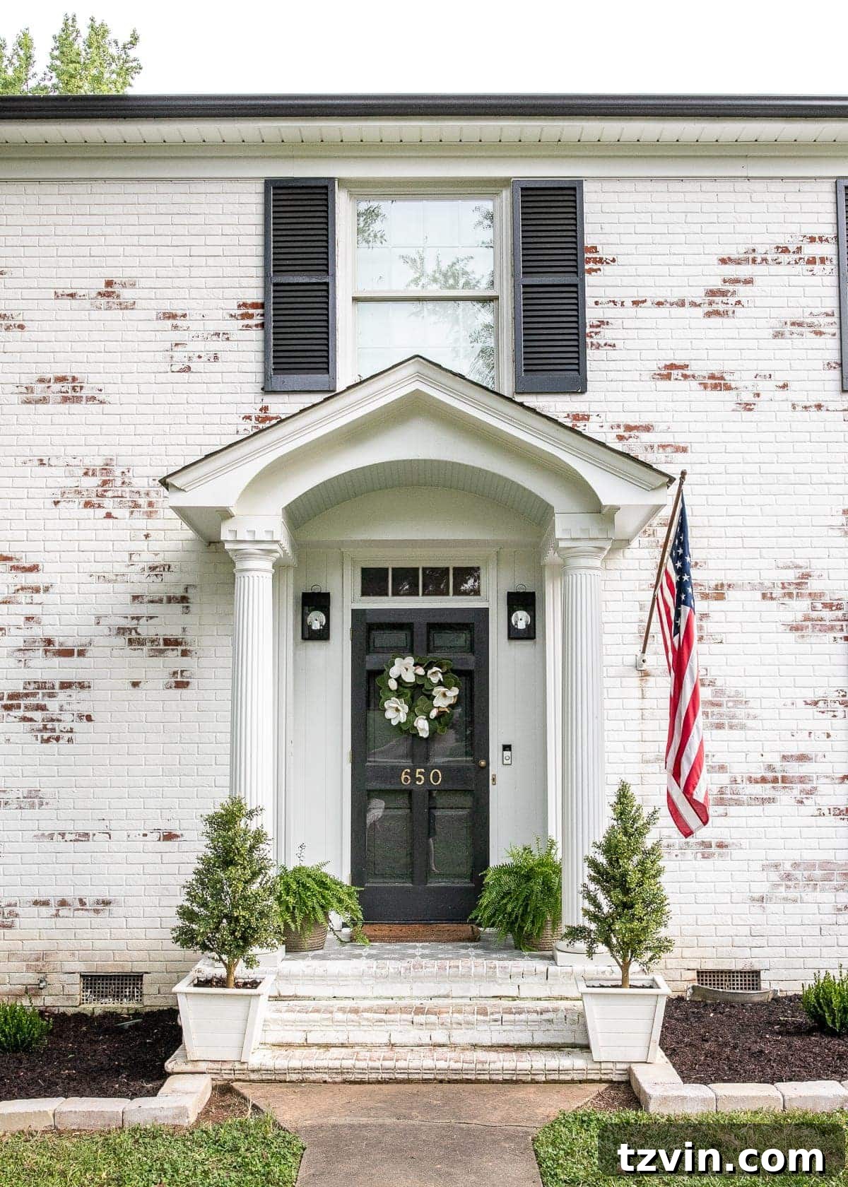 stenciled front porch with stone outlined flower beds