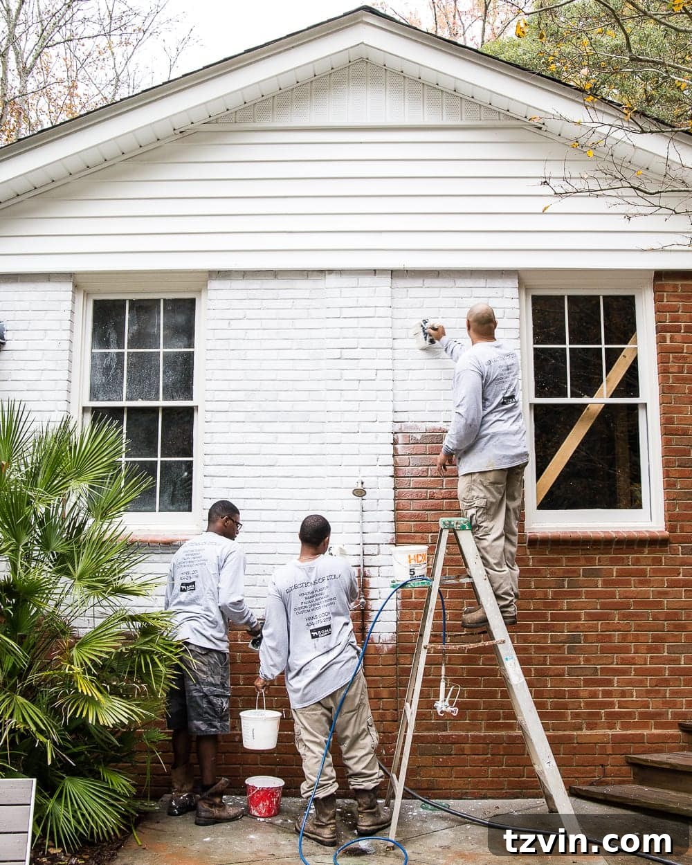 hand brushing Romabio Bianco White limewash paint on brick exterior