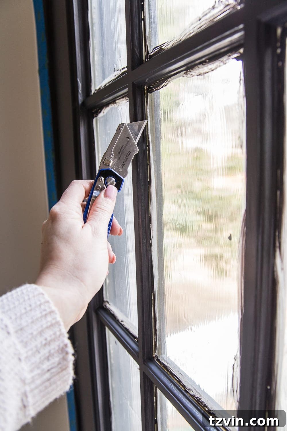 scoring masking liquid away from a French door window pane with a utility knife
