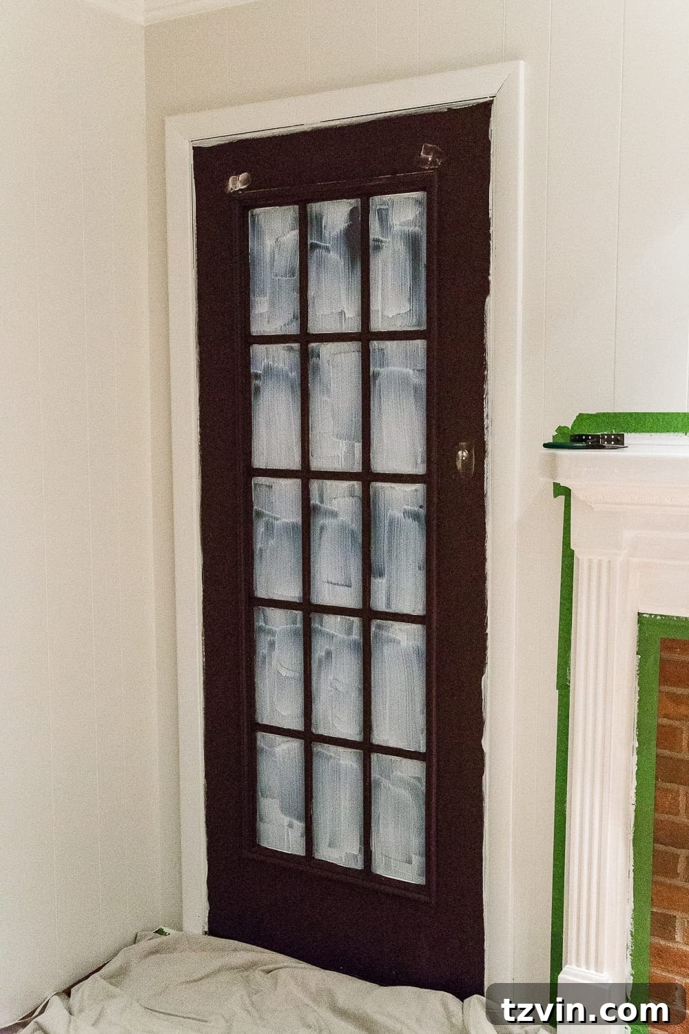 freshly applied white masking liquid on French door glass panes
