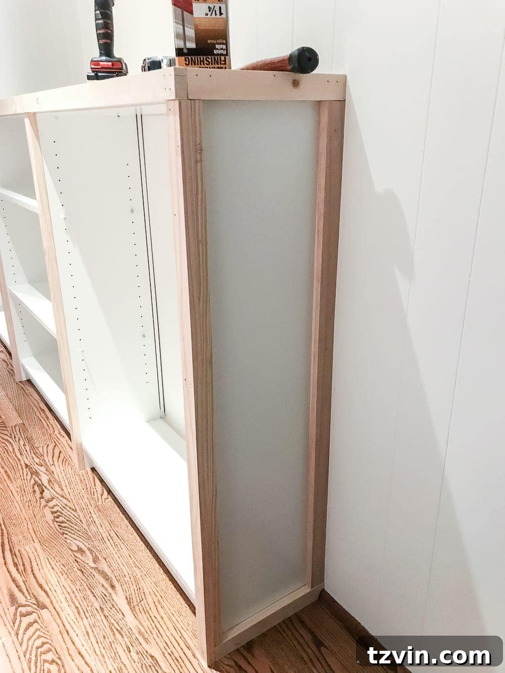 Custom Playroom Library Corner 19 Attaching the final 1x2 trim pieces to the outer sides of the IKEA Billy built-ins to complete the decorative panel look.