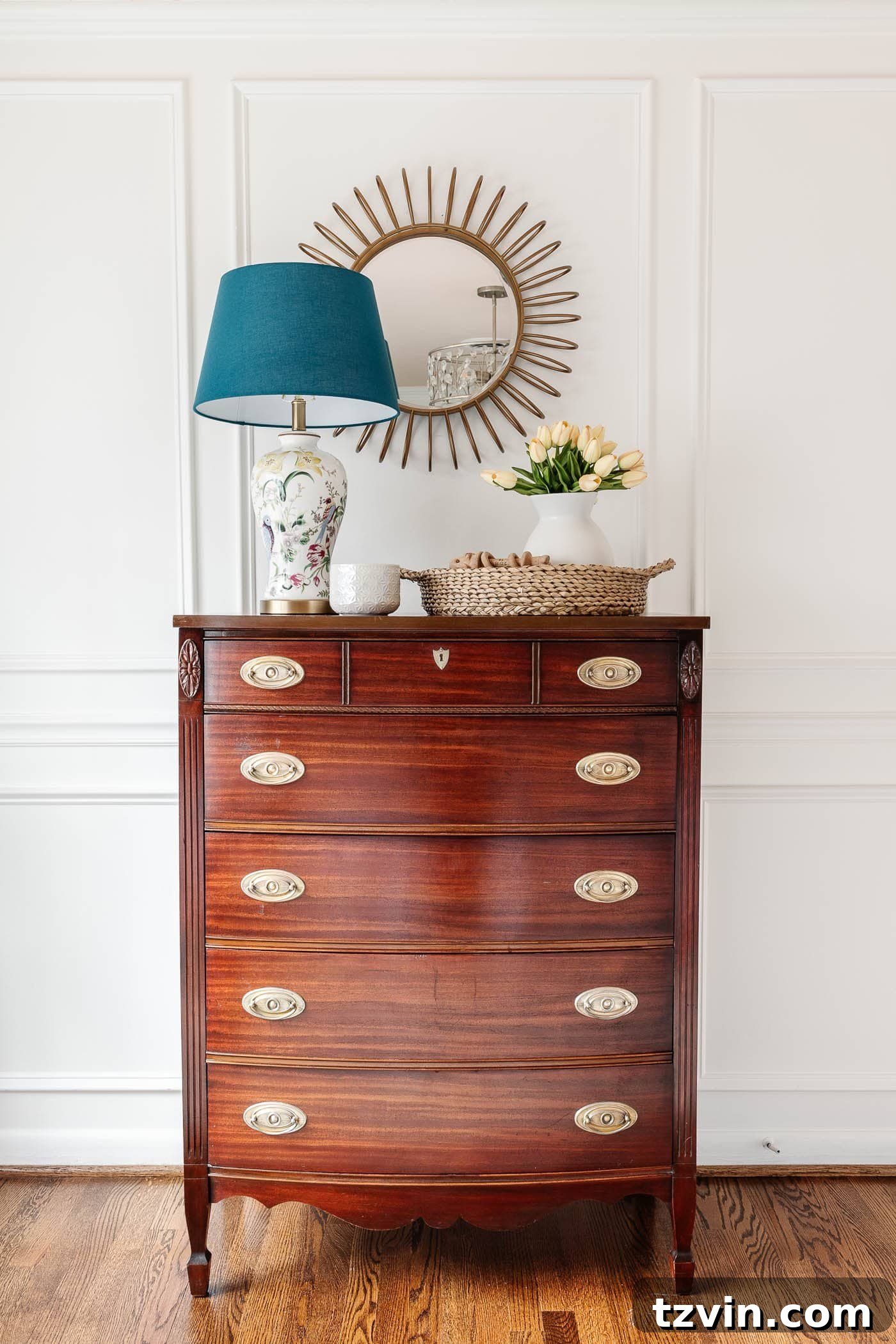 The Enduring Appeal of Classic Interior Design 12 A vintage wood chest of drawers adorned with a charming chinoiserie lamp, illustrating the timeless appeal of antique furniture.