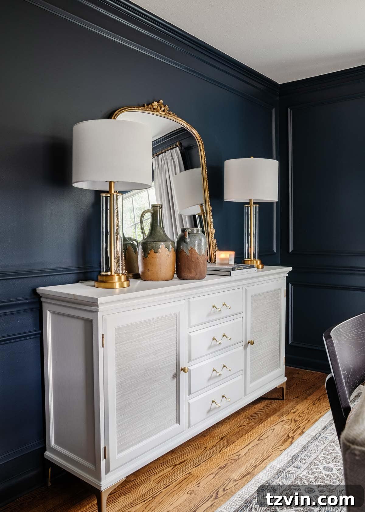 The Enduring Appeal of Classic Interior Design 16 A sophisticated navy blue dining room with a white sideboard and an elegant gilded mirror, highlighting the timeless appeal of navy.