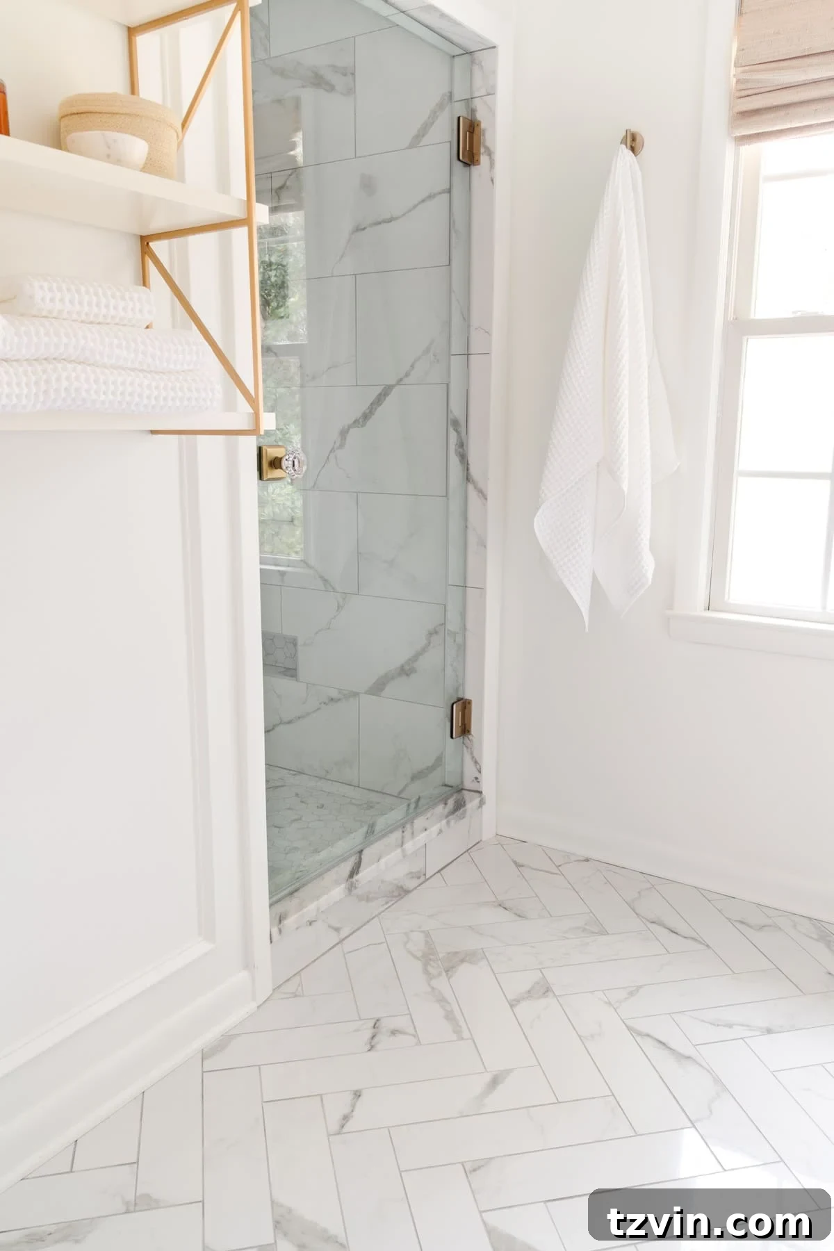 The Enduring Appeal of Classic Interior Design 24 Herringbone tile floors in a pristine white bathroom, showcasing a luxurious and timeless interior design.