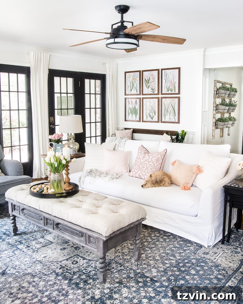 Spring Refresh Living Room Reveal 3 A dog rests on a light-colored sofa in a spring-decorated living room, highlighting comfort and easy living. Ideal for 'spring decor,' 'living room comfort,' and 'pet-friendly home design'.