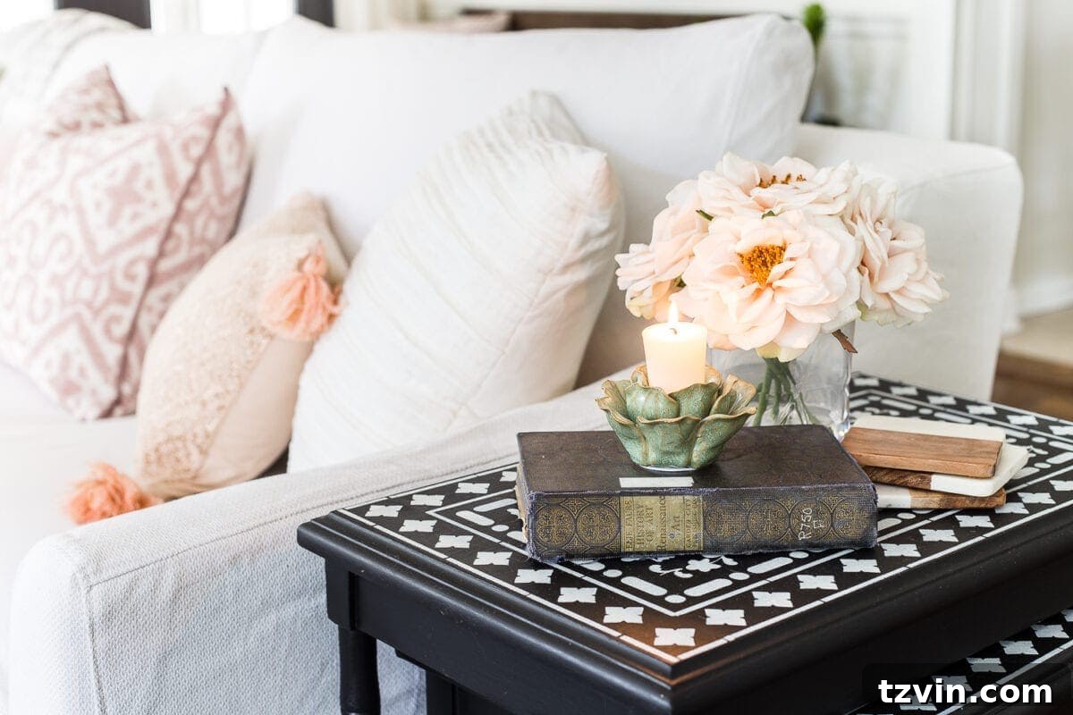 Spring Refresh Living Room Reveal 7 An antique book and fresh flowers adorn a tabletop, blending 'vintage charm' with 'spring accents' in a warm living room setting.