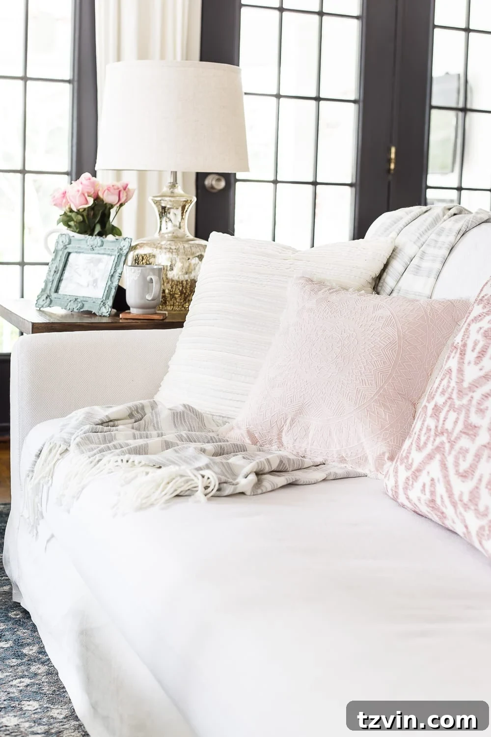Spring Refresh Living Room Reveal 8 Cozy sofa with an array of throw pillows and a blanket basket, creating an inviting 'spring decor' atmosphere for relaxation and family time.