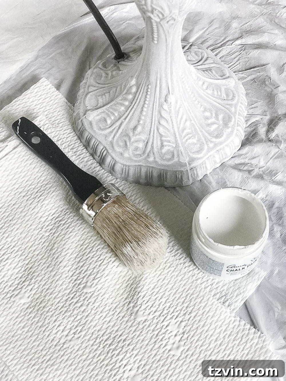 Olivia's Bedroom Transformation: A Baroque Lamp Revival 5 Demonstration of dry brushing technique with Annie Sloan Pure White Chalk Paint on a Baroque lamp to highlight intricate details during a DIY makeover.