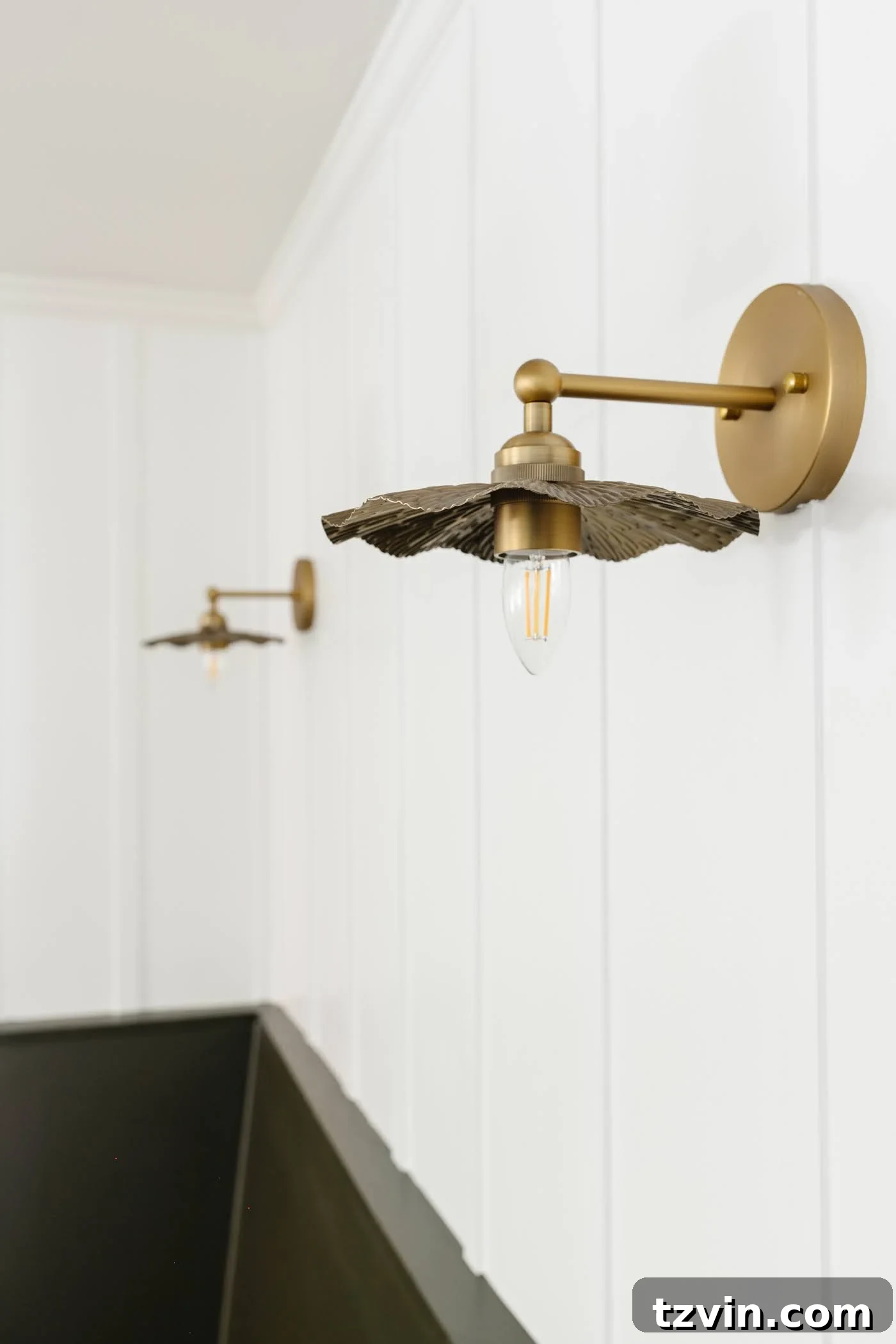 Ornate floral vintage wall sconces adorning a crisp white board and batten wall, adding a touch of classic charm.