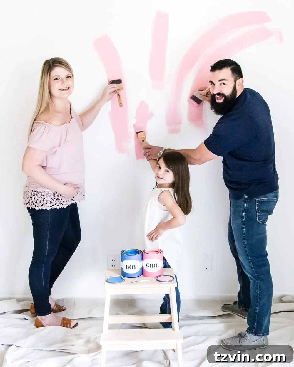 Our Budding Baby Reveal 6 The happy couple embracing after their gender reveal, surrounded by pink paint splatters on the nursery wall.