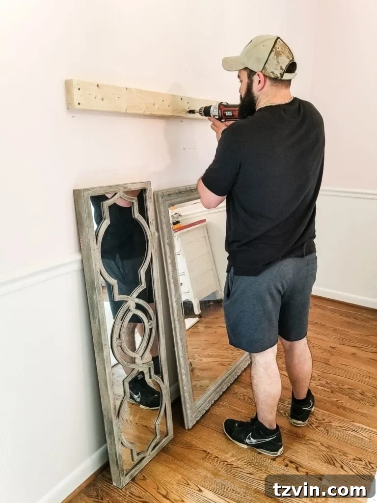 Crafting a Ballet Barre and Mastering Chair Rail Decor 3 Installing the 2x4 boards to the wall studs for a DIY ballet barre. Showing how to secure wood boards for mirror hanging above a chair rail. #DIYKidsRoom #BalletBarreDIY #HomeStudio #WallMounting