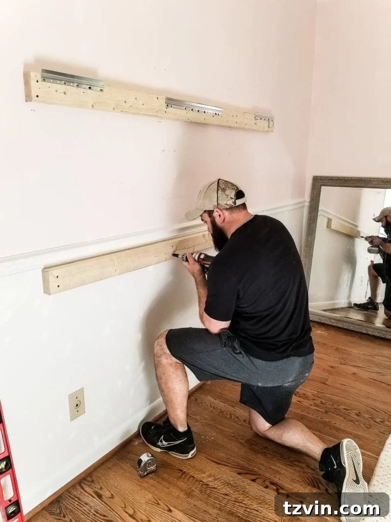 Crafting a Ballet Barre and Mastering Chair Rail Decor 4 Lower 2x4 board installed below the chair rail for ballet barre brackets. Demonstrating how to create a flush surface for wall decor on board and batten. #DIYHomeDecor #KidsBedroomIdeas #BalletBarreInstallation #ChairRailHack
