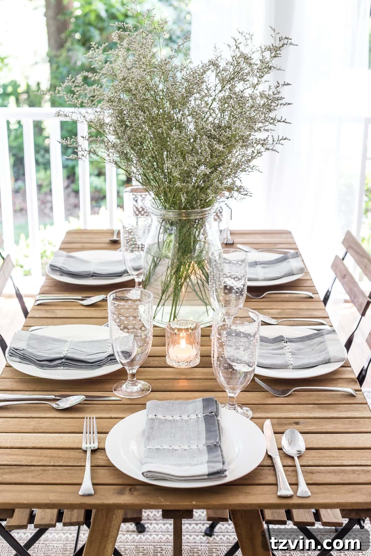 A close-up of the outdoor dining table set with place settings, ready for an al fresco meal.