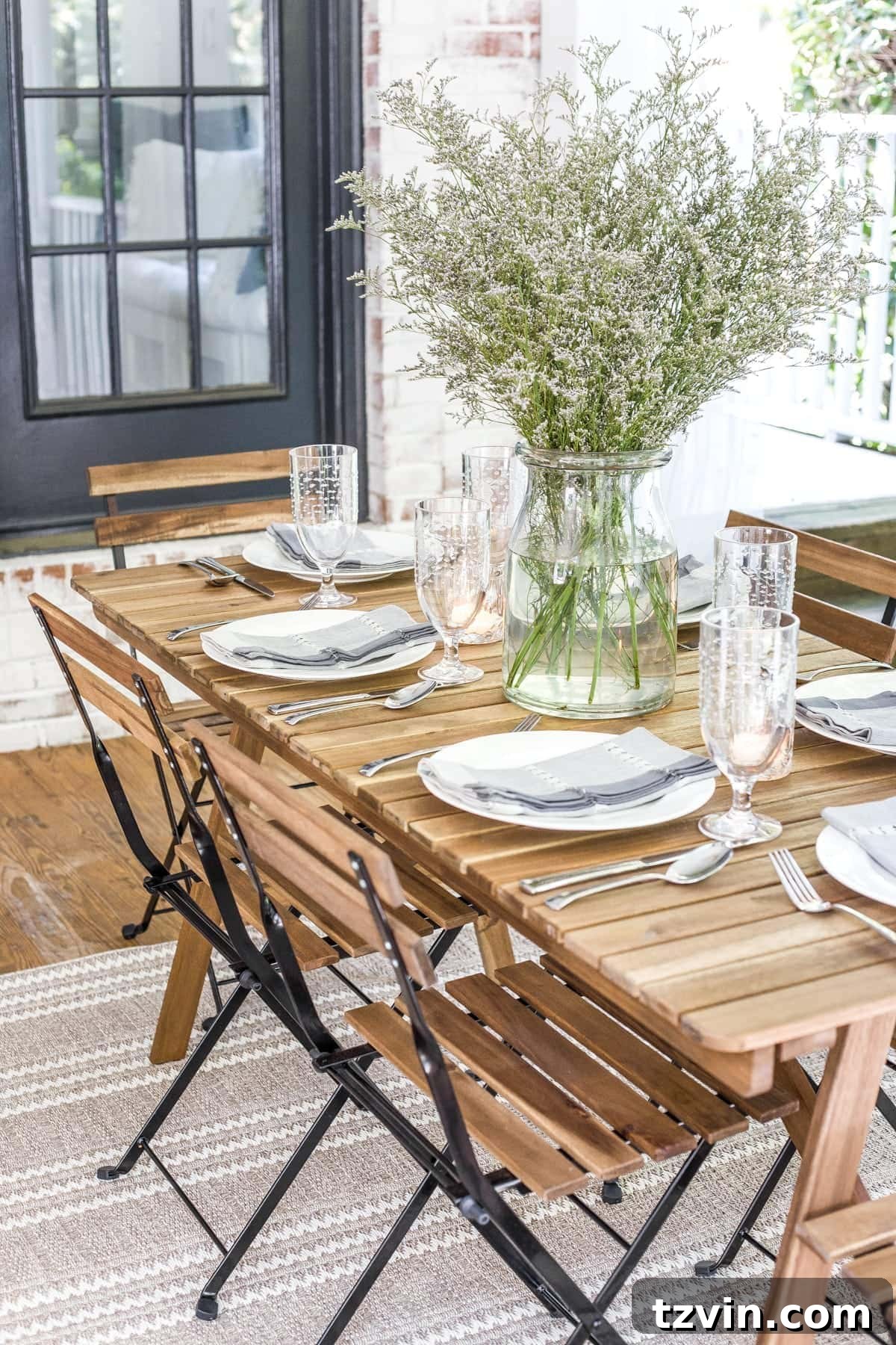 The outdoor dining table on the back porch, set against the backdrop of the inviting outdoor space.