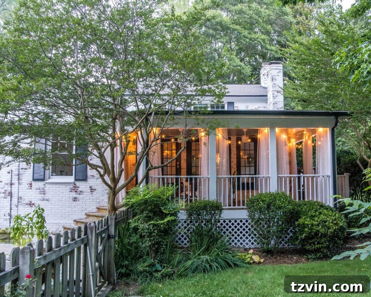 The newly limewashed brick house exterior with a beautifully decorated porch, illuminated by string lights.