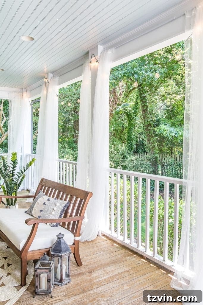 Sub-$100 Porch Paradise: DIY Curtains & Screens 5 Elegant back porch featuring DIY outdoor curtains on tension rods secured by Command hooks, highlighting a haint blue ceiling and inviting atmosphere.