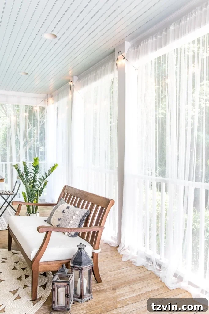 Sub-$100 Porch Paradise: DIY Curtains & Screens 6 Mosquito net outdoor curtains creating a screened effect on a back porch, complemented by a haint blue ceiling, offering both protection and beauty.