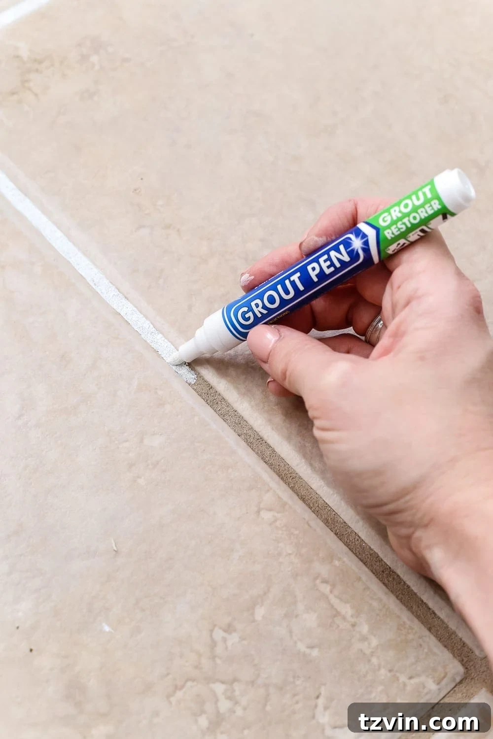 Kitchen Floor Refresh Memory Foam Comfort and Grout Rejuvenation 6 Close-up of a hand using a grout pen to refresh dirty grout lines