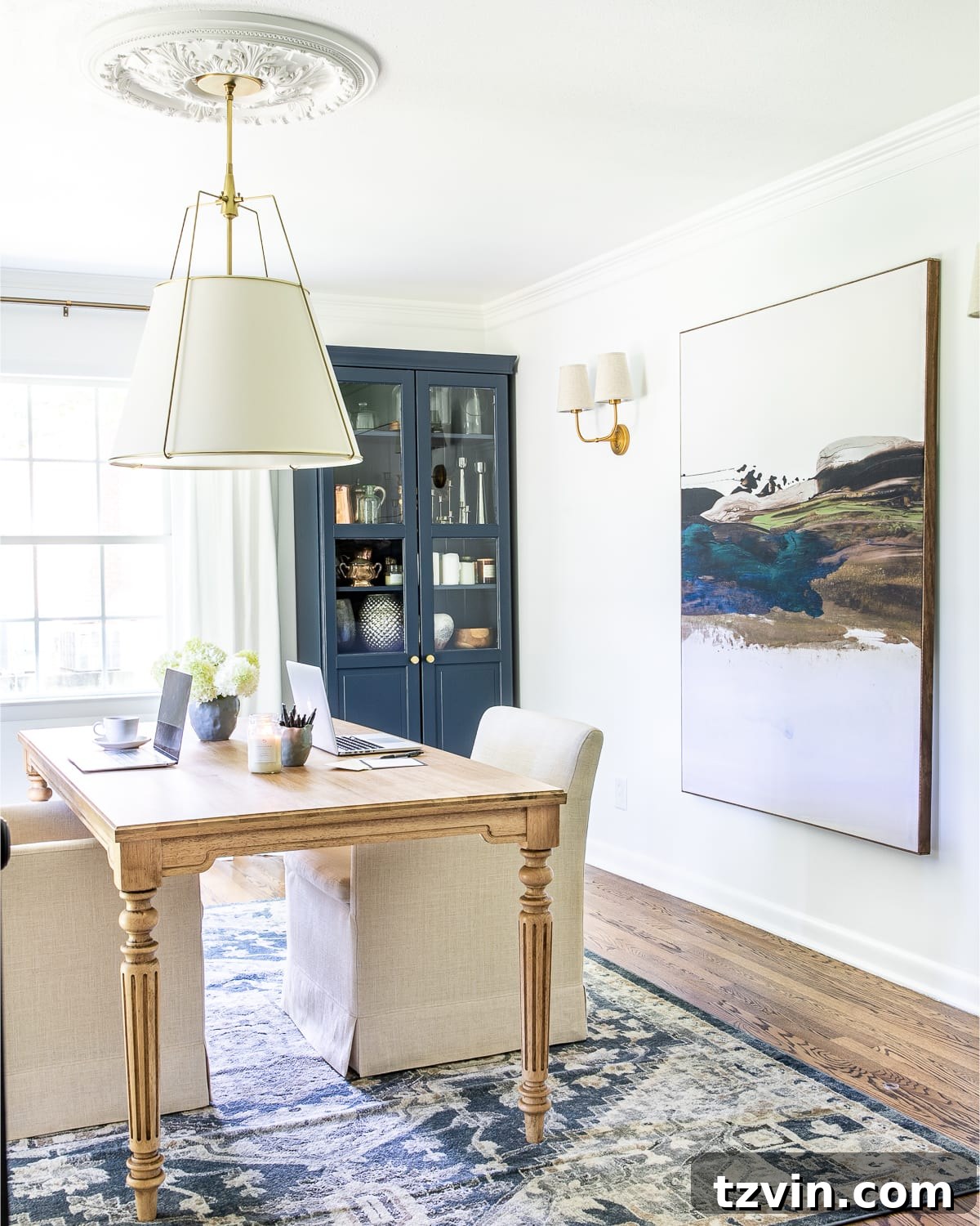 23 Smart Hacks to Make Your Small Room Feel Instantly Bigger 11 home office with oversized art made of a shower curtain, navy blue storage cabinet, and work table with rolling chairs