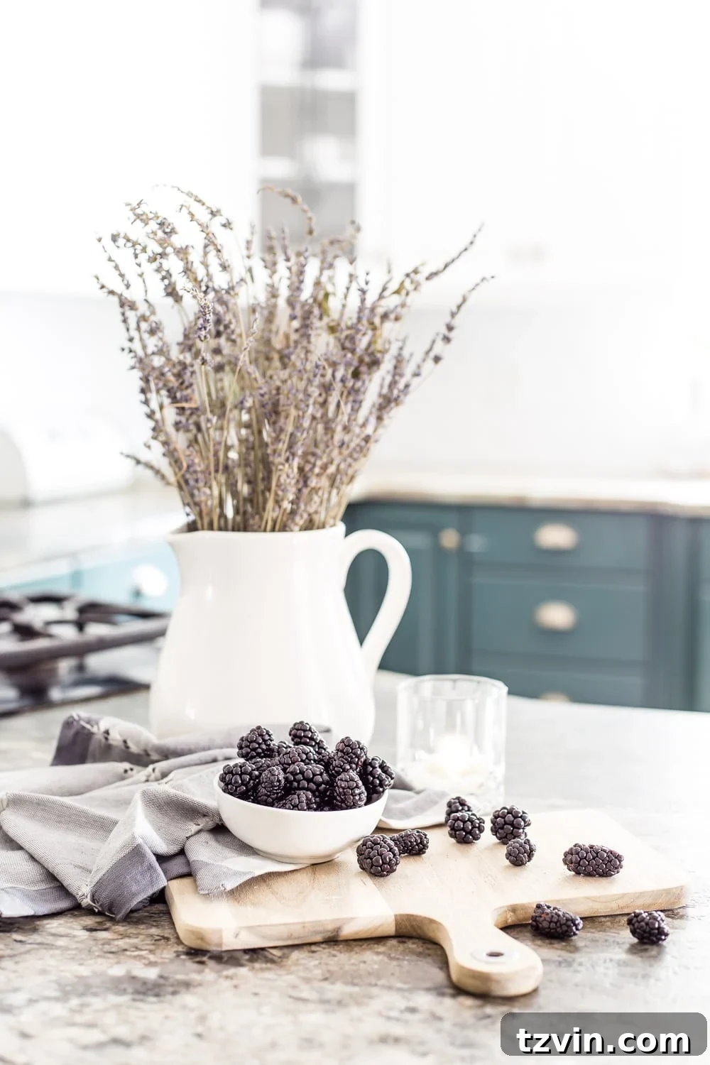 30 Must-Have Home Decor Treasures from Thrift Stores 20 A pitcher, a thrifting must-have, used as a watering can in a kitchen setting.
