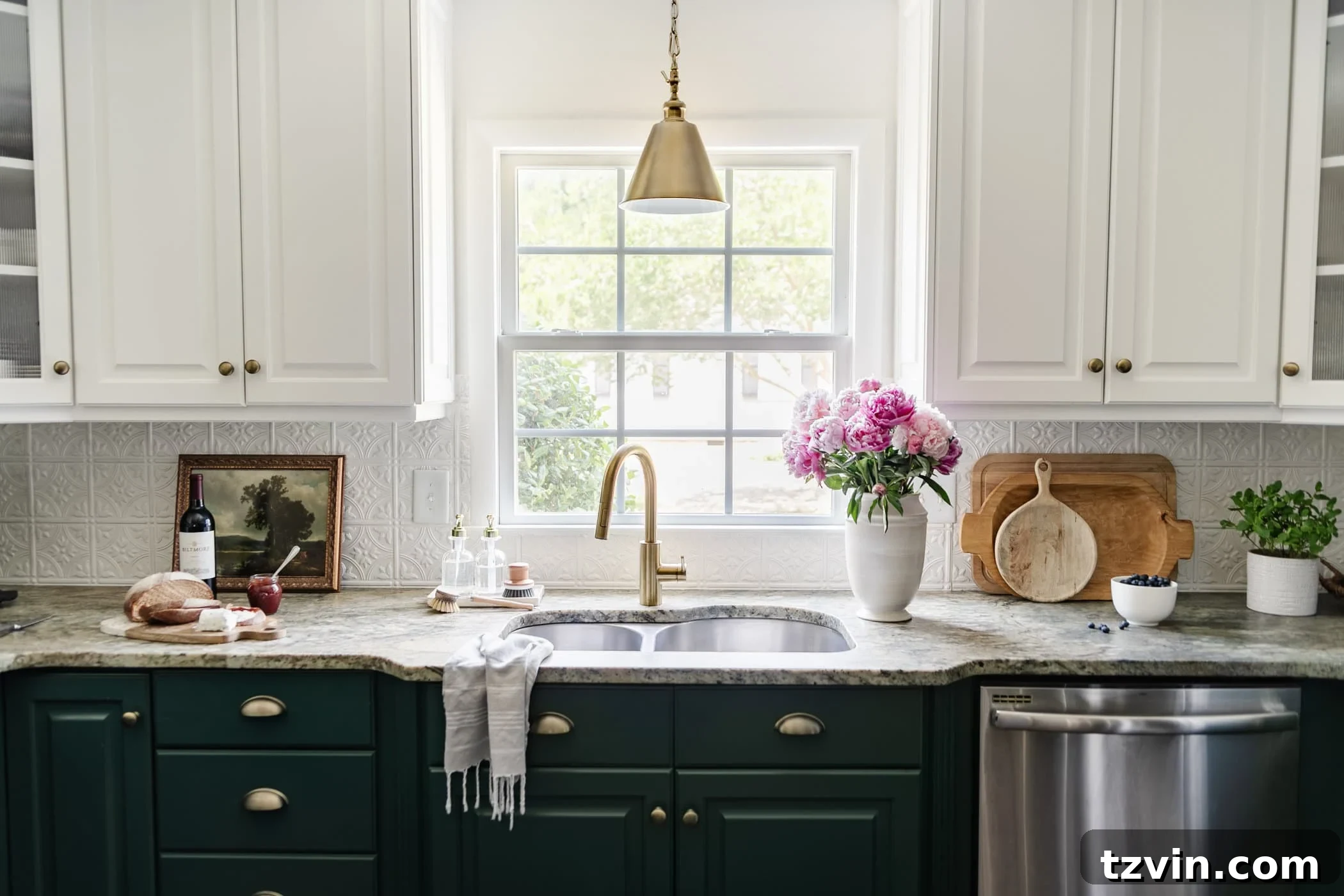 Cozy Cottagecore Kitchen Transformations for Less 13 kitchen sink in front of window with white vase of pink peonies, antique art, and cuttingboards on a countertop