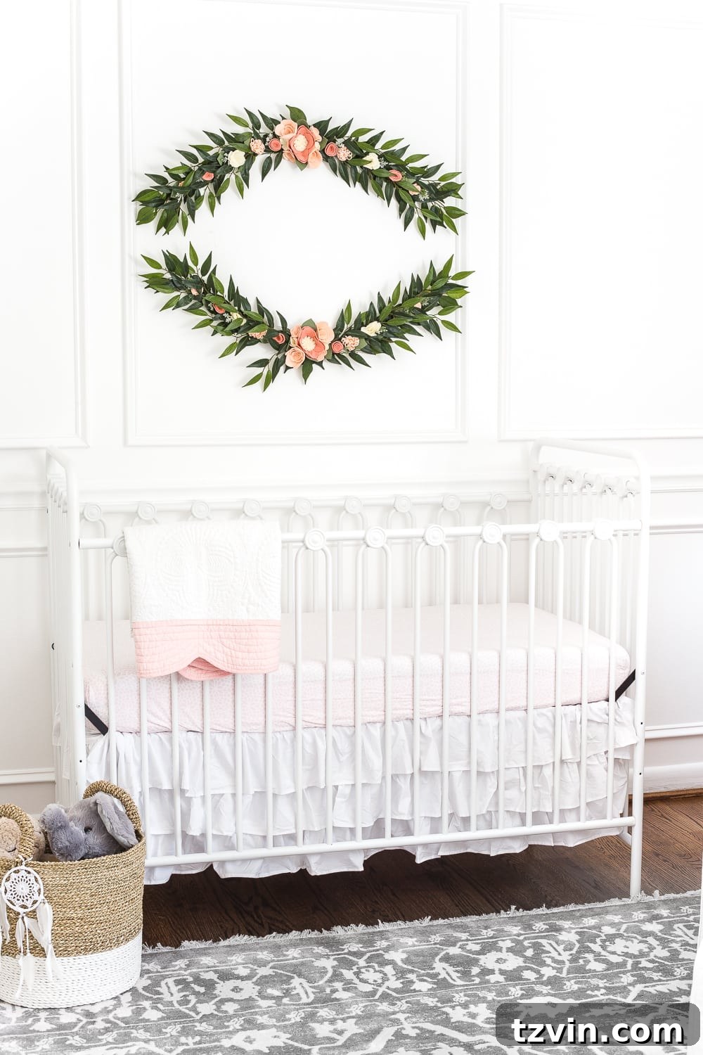 Blossoming Dreams: White Floral Nursery Reveal 11 Crib with pale pink sheet and ruffled skirt in the white nursery.
