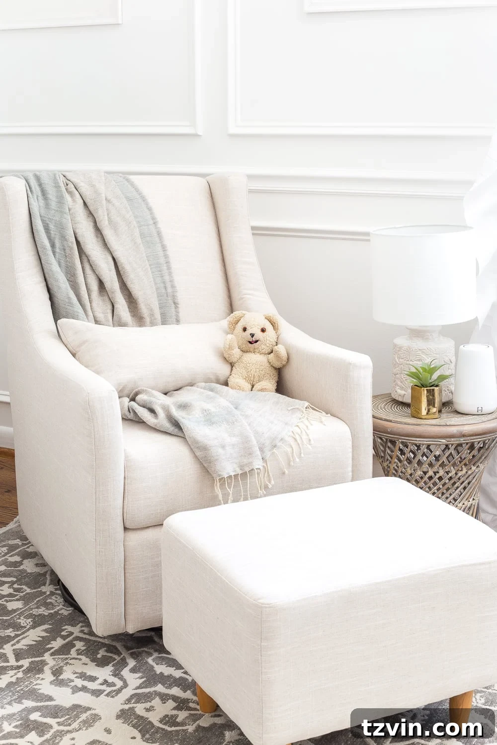 Blossoming Dreams: White Floral Nursery Reveal 17 Accent table with a lamp next to the glider in the white nursery.