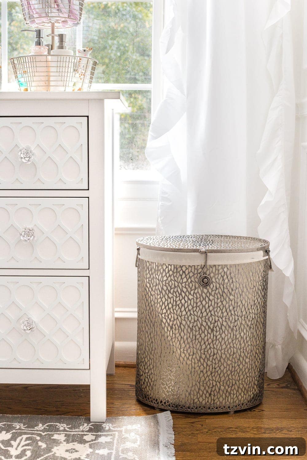Blossoming Dreams: White Floral Nursery Reveal 20 Lidded hamper next to the dresser in the white nursery.