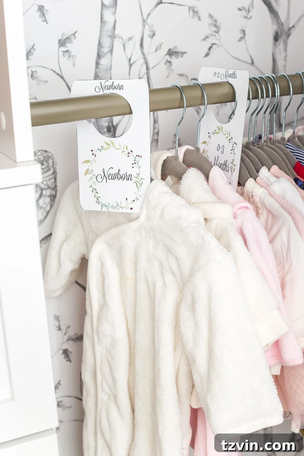 Nursery closet with free printable closet divider tags on hanging clothes