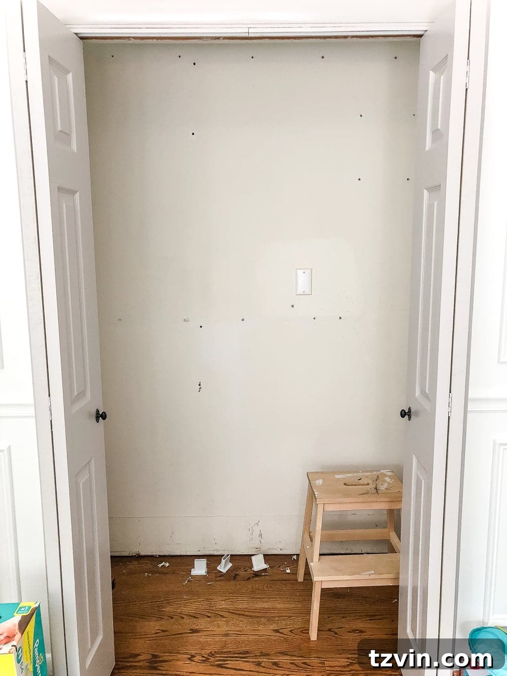 Nursery closet with old wire shelving removed and walls ready for preparation