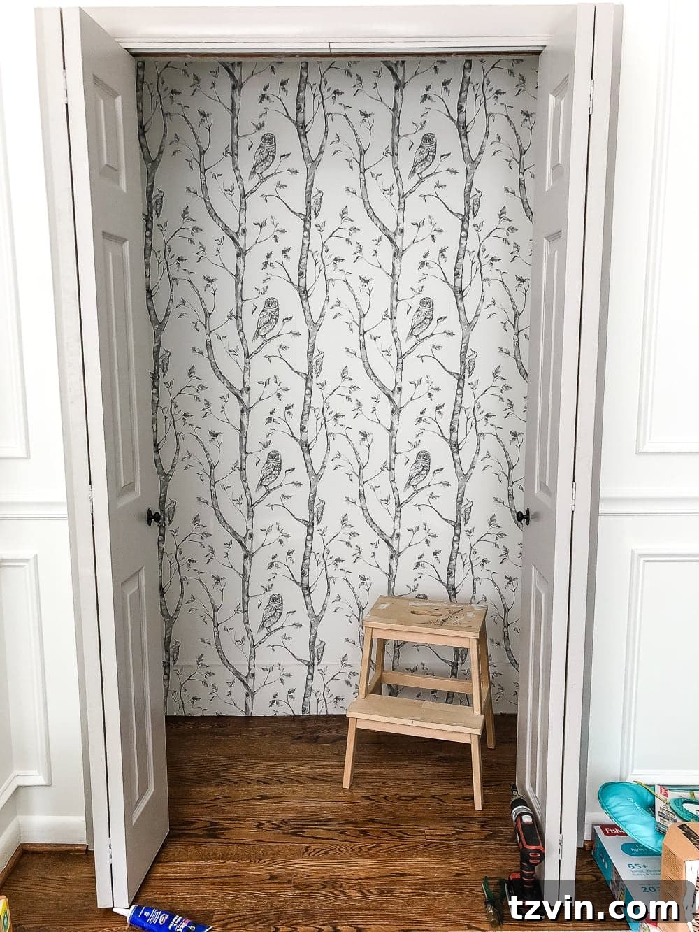 Nursery closet interior with elegant peel and stick gray birch tree wallpaper