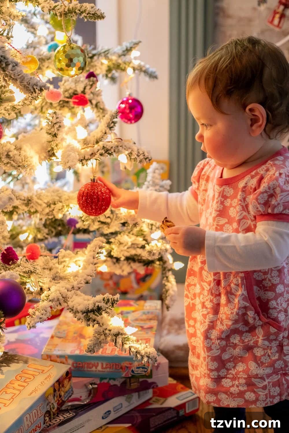 DIY Christmas Magic: Easy Family Photos at Home 6 Toddler standing beside a Christmas tree, illuminated by natural light for a DIY Christmas photoshoot