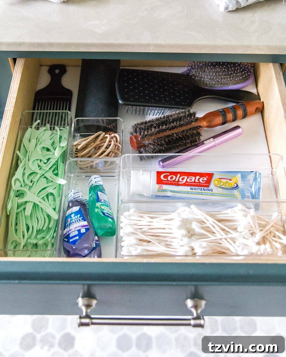 Top bathroom drawer organized with shared items like toothpaste, floss, and mouthwash, using clear dividers. #SharedBathroomItems #DentalHygiene #FamilyOrganization