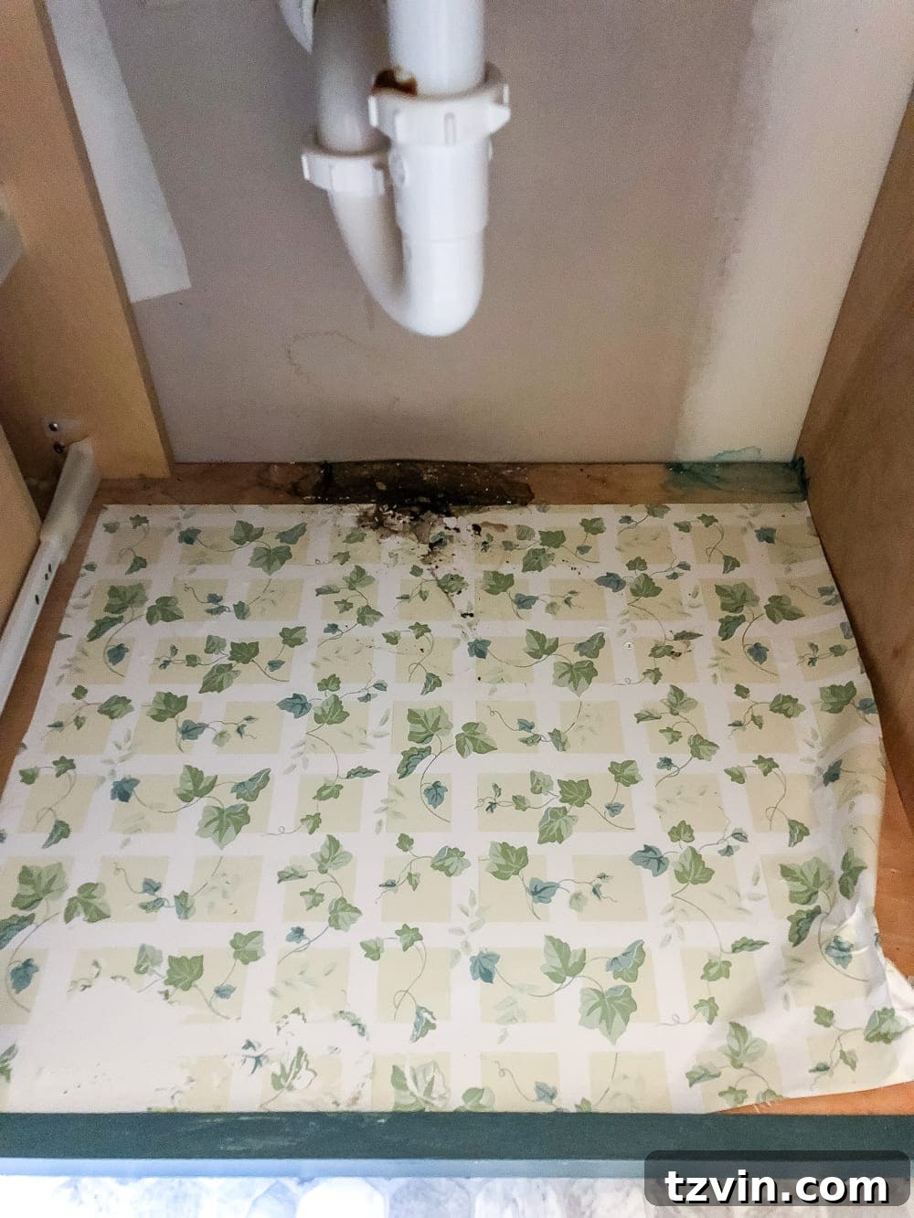Applying new white wood grain contact paper to the bottom of a cleaned bathroom vanity drawer. #DrawerLiner #DIYOrganization #BathroomRefresh