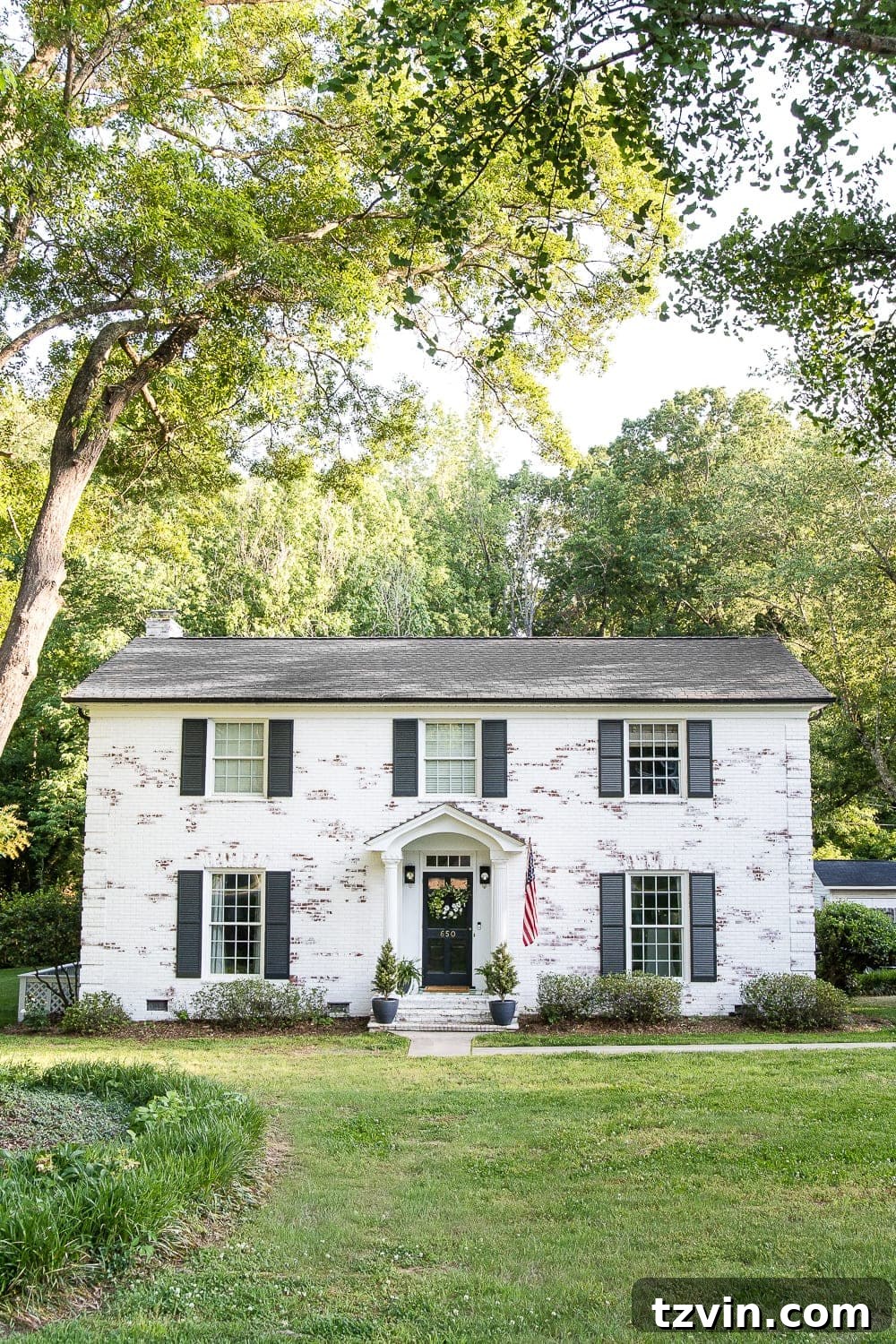 Two Years In: Our Home's Stunning Before and After 2 Charming 1960s brick colonial home exterior with lush landscaping, a perfect blend of modern and traditional styles.